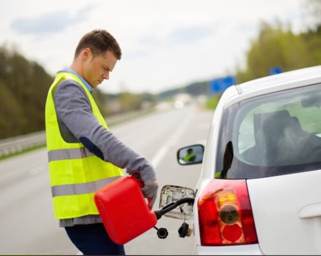 Roadside technician in hi-vis vest delivering fuel to a stranded vehicle on Edmonton highway